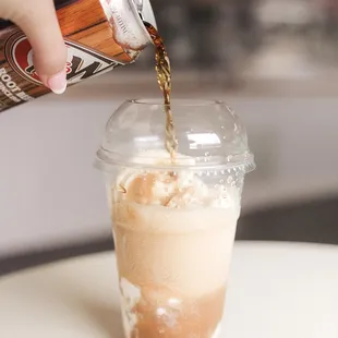 a person pouring coffee into a cup