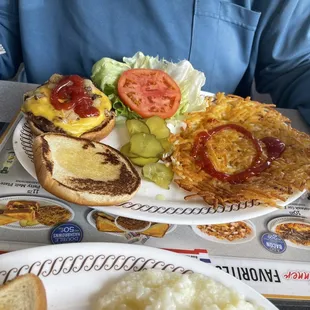 Angus cheeseburger with lettuce and tomato and a side of hash browns