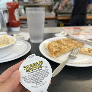 a person holding a waffle in front of a plate of waffles