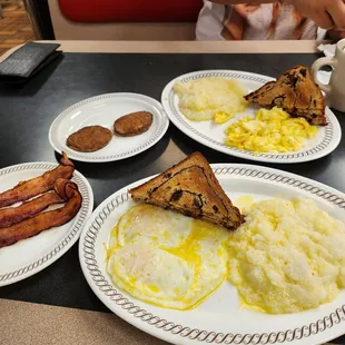 a breakfast of eggs, bacon, toast, and hash browns