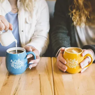 two women sitting at a table with cups of coffee