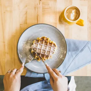 a person eating a waffle on a plate