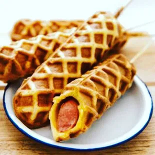 a plate of waffles with hot dogs
