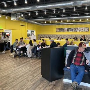 a crowd of people sitting in a yellow room