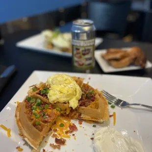 a waffle with eggs, bacon, bacon, and cheese