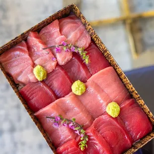 a person holding a box of raw tuna