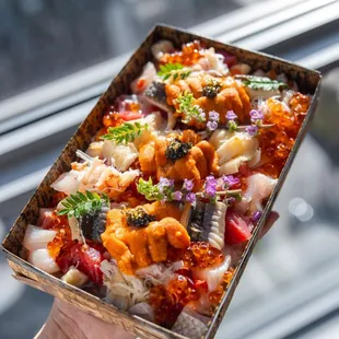 a hand holding a box of food