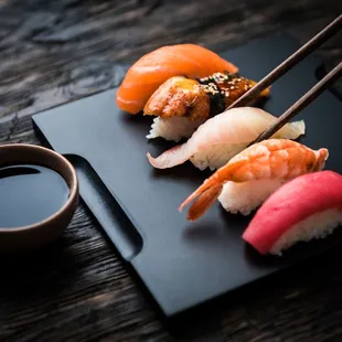 a plate of sushi with chopsticks