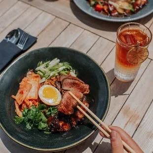 a person holding chopsticks over a plate of food