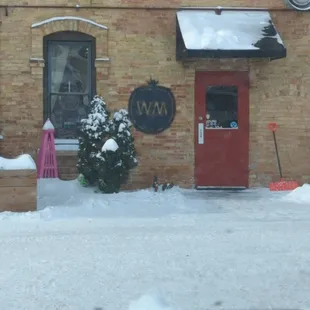 the front of the building with snow on the ground