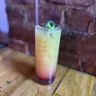 a drink with a straw and a garnish