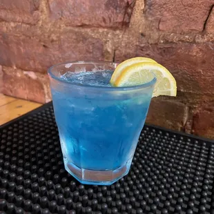 a blue drink with a slice of lemon