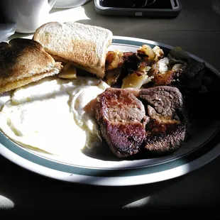 Steak, eggs, toast, and fried potatoes. Only 8 bucks and change.