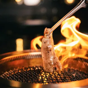 a hot dog being cooked on a grill