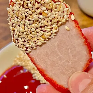 a hand holding a half eaten strawberry