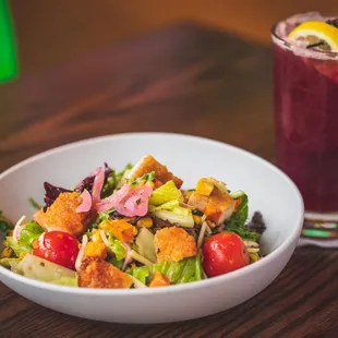 a bowl of salad and a drink