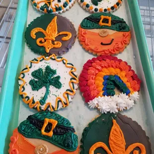 a tray of decorated cupcakes