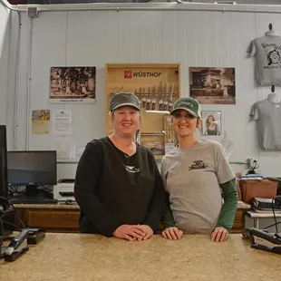 two people standing behind a counter