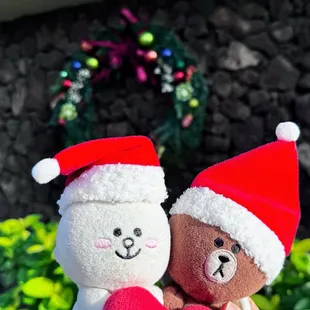 Cony and Brown sporting Santa hats by the festive holiday wreath at the front of Waialae CC.