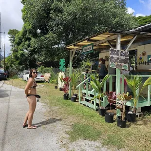 a woman standing in front of a fruit stand