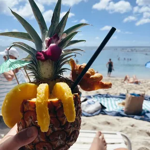 a person holding a pineapple drink