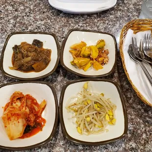 Complimentary banchan side dishes (kimchi, bean sprouts, pickled eggplant, bamboo)