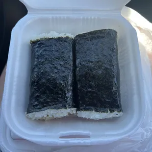 two pieces of sushi in a styrofoam container