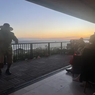 a man standing on a balcony overlooking the ocean