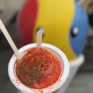 a hand holding a cup of ice cream