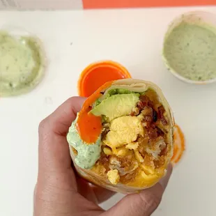 The OG Bacon breakfast burrito. With the cilantro sauce and hot sauce. Perfect bite.
