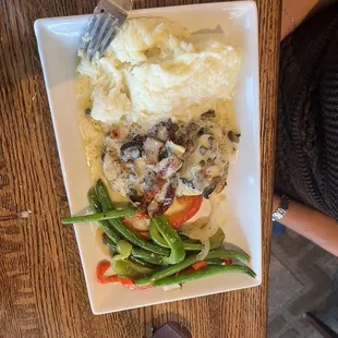 a plate of food with mashed potatoes, green beans, and mushrooms