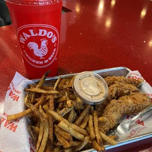 Chicken tenders, fries, sauce, and a 32 ounce drink in a souvenir cup
