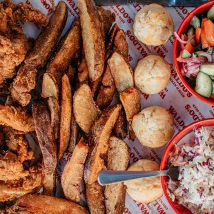 a plate of fried chicken, fries, coleslaw, and a side salad