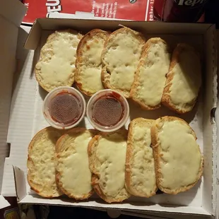 a box of slices of bread with cheese and ketchup