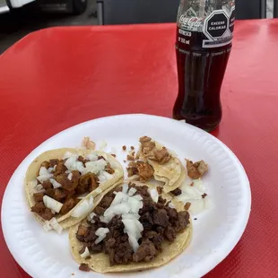 Carne Asada taco in front and Al Pastore and chicken tacos behind it.