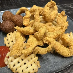 Catfish dinner with waffle fries and hush puppies