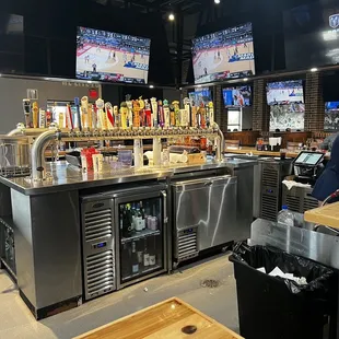 a bar with stainless steel counter tops and bar stools