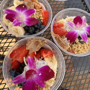 three bowls of fruit and granola