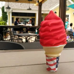 Small cherry dipped vanilla cone.