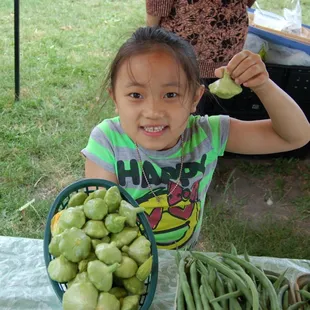 Our littlest vendor showing a basket of patty pan.