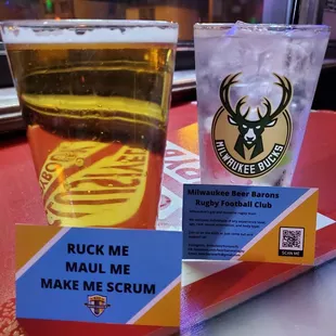 a glass of beer and a sign on a table