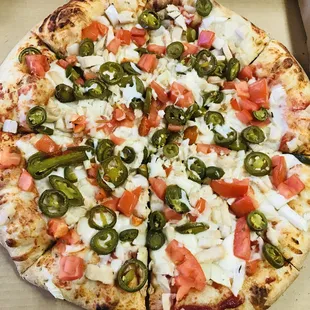a pizza with jalapenos and tomatoes