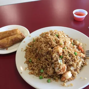a plate of fried rice with shrimp and vegetables