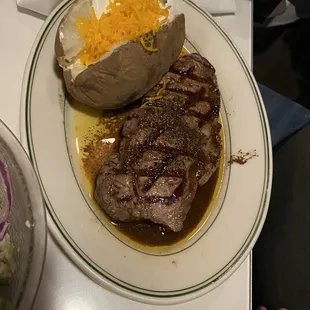 a plate of steak and a baked potato
