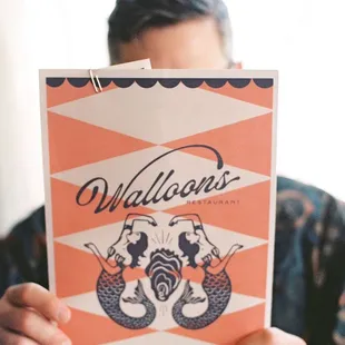 a man holding up a menu