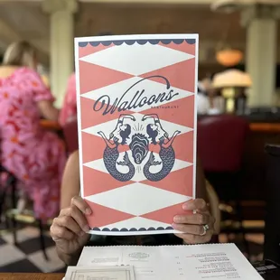 a person holding up a menu