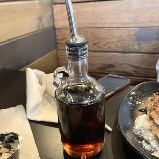 a bottle of syrup and a plate of food