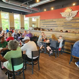 a large group of people sitting at tables in a restaurant