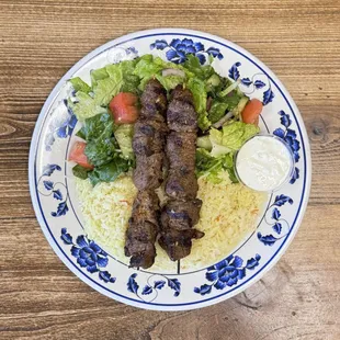 Lamb Kabobs Plate - 2 lamb skewers served with rice, salad, tzatziki &amp; pita