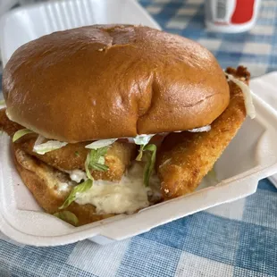 a fried chicken sandwich in a styrofoam container